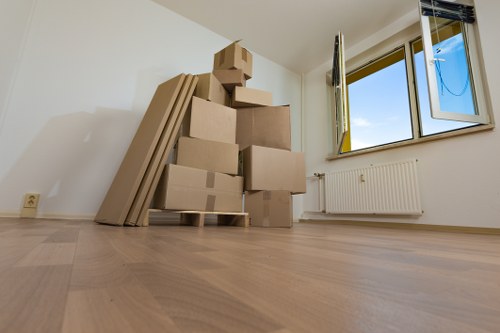 Removal professionals carrying furniture through a Kensington property