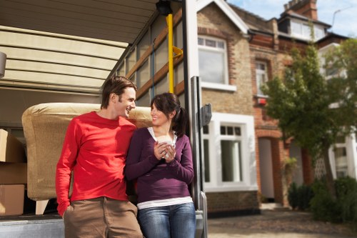 Removal professionals carrying items through a Kensington flat staircase